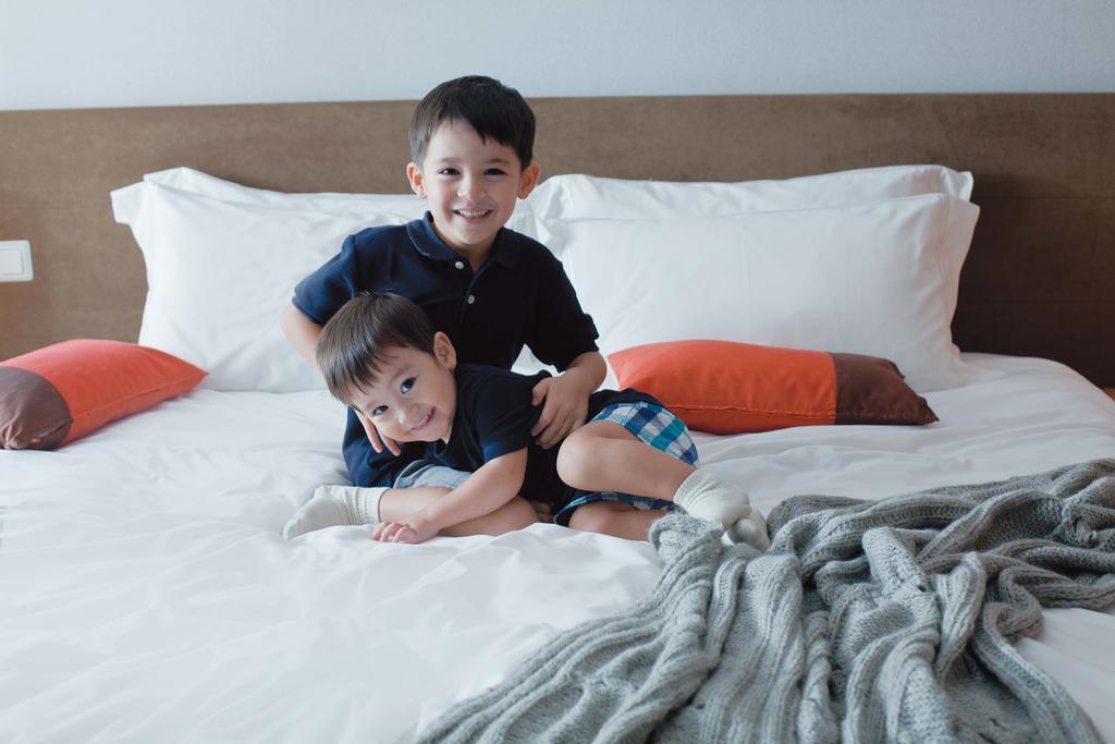 Fraser Place Robertson Walk Singapore Eksteriør billede Two children playing on a bed